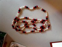 All pearls are fresh waters of various shapes. Red and gold ones are dyed. Peach and mauve ones are natural color I think, no visible evidence of dyeing at the holes or in ant of the pits and other imperfections on the pearls where dye tends to collect. Amethyst, garnet, and black onyx beads were also used