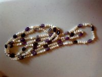 All pearls are fresh waters of various shapes. Red and gold ones are dyed. Peach and mauve ones are natural color I think, no visible evidence of dyeing at the holes or in ant of the pits and other imperfections on the pearls where dye tends to collect. Amethyst, garnet, and black onyx beads were also used