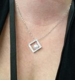 Hisano fixed this pendant by replacing the pearl that fell off with a metallic white pearl on a wire dangle