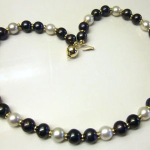 Black Beauty Meets Snow White.
10mm. dyed black freshwater pearls with white South Sea pearls and solid gold accent beads and clasp.