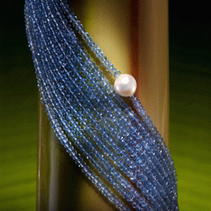 Microfaceted blue topaz necklace on banana trunk