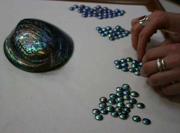 Grading and sorting abalone mabe pearls.